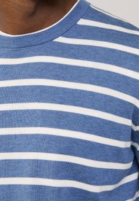 Modro-bílý pruhovaný svetr s kulatým výstřihem, vyrobený z měkké pletené látky, se stejnými vodorovnými pruhy a texturovaným povrchem.