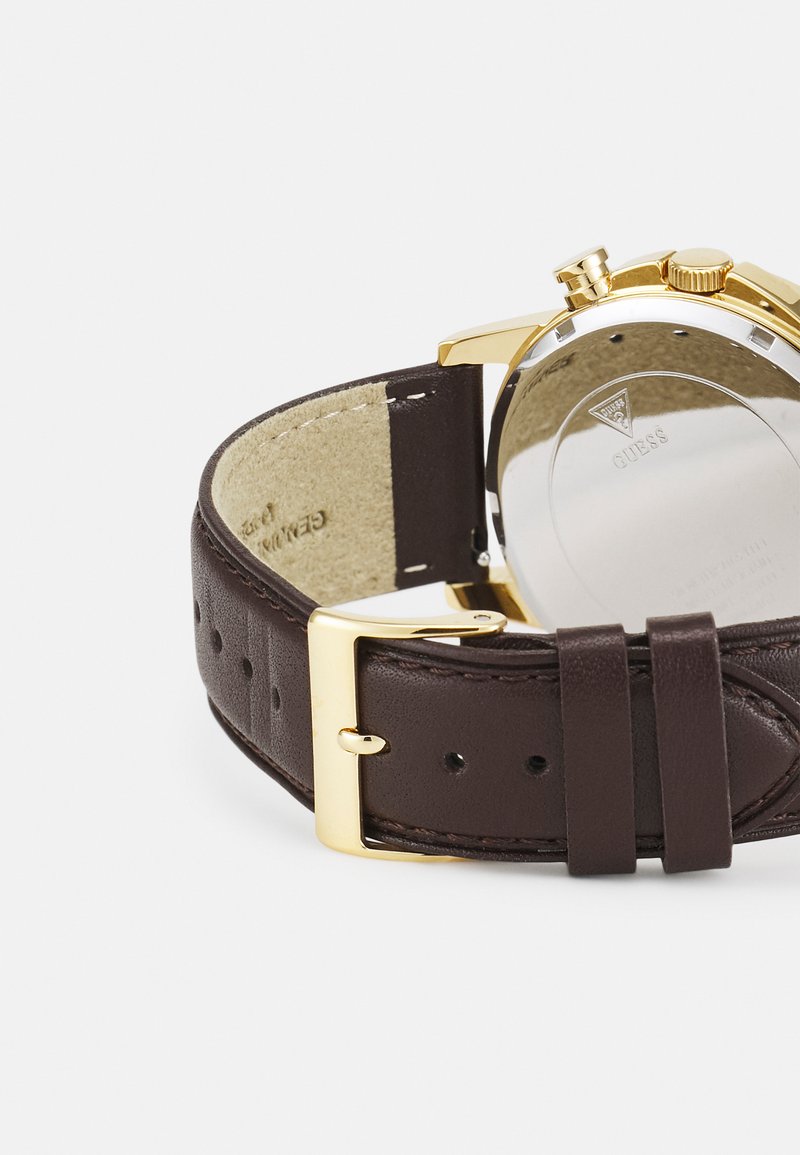 Braunes Lederarmband mit einem Gehäuse aus goldfarbenem Edelstahl, sichtbarer Schnalle und eingraviertem Markenlogo auf der Rückseite.