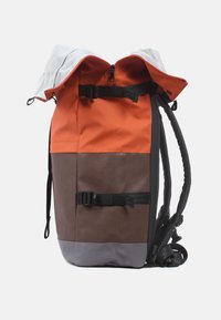 Wasserabweisender Rucksack mit orangefarbenen und braunen Paneelen, grauem Boden, verstellbaren Trägern und oben mit einem Reißverschluss und einer Schnalle gesichert.
