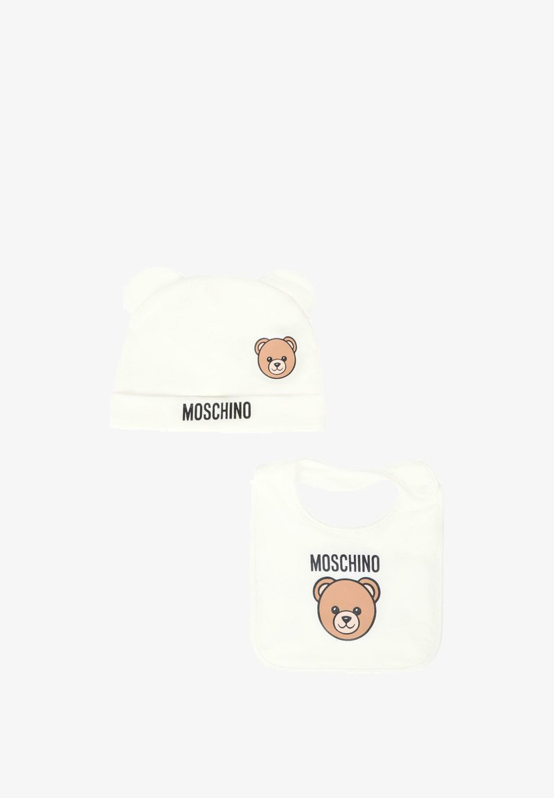 Beanie bianco in cotone con orecchie da orso e faccia di orso stampata; bavaglino abbinato con faccia di orso e branding "Moschino". Texture morbida, design semplice.