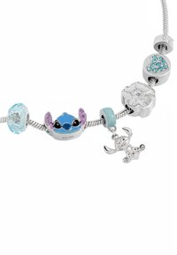 Bracciale con charm a tema Disney, caratterizzato da una catena in argento con perline colorate, un charm di Stitch blu, un charm a forma di fiore e una perlina a forma di cuore con gemme.