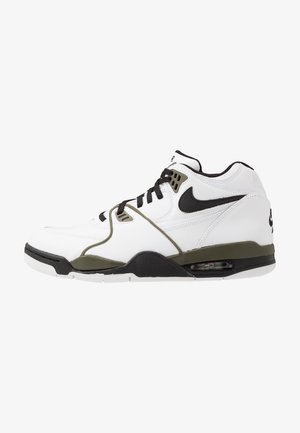 Baskets montantes Nike Air blanches et olive avec logo swoosh noir, lacets noirs et coussin d'air visible dans la semelle.