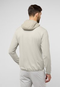 Lichtbeige hoodie met lange mouwen, elastische zoom en een zachte stoftextuur. Kenmerkt zich door een eenvoudig ontwerp zonder extra patronen.