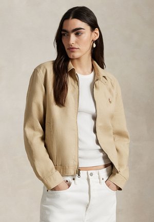 Μπεζ βαμβακερό μπουφάν με εφαρμοστό σχεδιασμό, κλείσιμο με φερμουάρ και πλαϊνές τσέπες. Διαθέτει διακριτική κεντημένη λογότυπο και απαλή υφή.