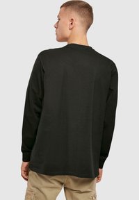 Schwarzes Langarm-T-Shirt aus Baumwolle, mit Rundhalsausschnitt und lässiger Passform. Der Stoff wirkt glatt, ohne sichtbare Muster oder Akzente.