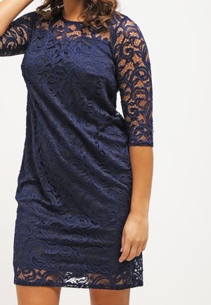 Navyblauwe kanten jurk met driekwart mouwen, voorzien van een textuur met bloemmotief en een gevoerde binnenkant voor bedekking. Ontspannen pasvorm.