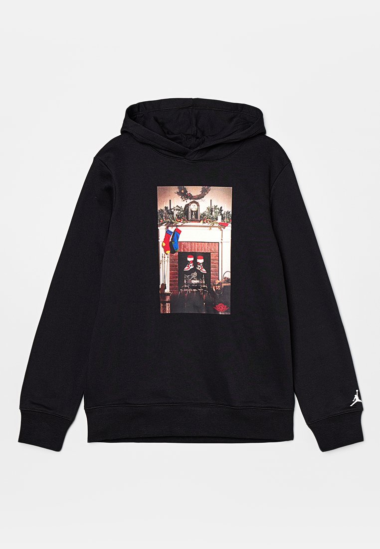 Hoodie noir avec un graphique central représentant une scène de cheminée avec des bas de Noël et une horloge, fabriqué en tissu doux avec des poignets côtelés.