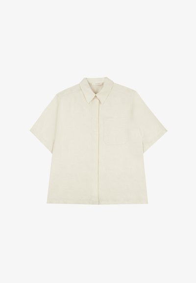 Camicetta a maniche corte di colore crema chiaro, realizzata in lino. Presenta un colletto a punta, chiusura frontale con bottoni e una tasca sul petto.