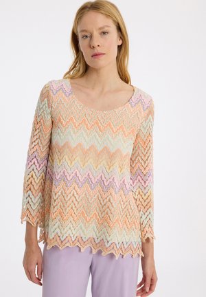 Kanttop met een golvend zigzagpatroon in pastelkleuren: oranje, lavendel, muntgroen en creme. 3/4 mouwen en een ronde hals.