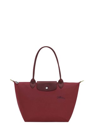 Burgundy tote bag made from nylon, featuring leather accents, a snap closure, and two sturdy handles. Includes logo detail on the front.