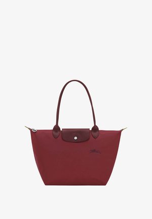 Burgundy tote bag made from nylon, featuring leather accents, a snap closure, and two sturdy handles. Includes logo detail on the front.