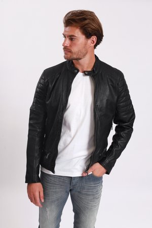 Zwarte leren motorjack met ribbeldetails op de schouders, slim fit, met ritszakken en een opstaande kraag, gecombineerd met een wit T-shirt.
