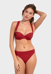 Červený bikini set se strukturovaným, podšitým topem s širokými ramínky a hladkým, vysokým spodním dílem. Vyrobeno z měkké, texturované tkaniny.