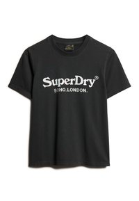 Camiseta de algodón negra de manga corta, con un logotipo gráfico blanco que dice "SuperDry SOHO.LONDON." a lo largo del pecho. Cuello redondo clásico.