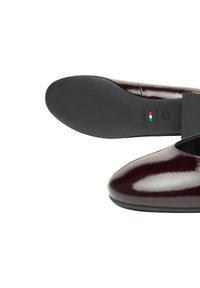 Scarpe in pelle verniciata borgogna con finitura liscia, punta arrotondata e suola in gomma. Presentano il marchio italiano sulla suola.