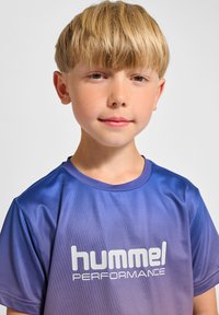 Hummel prestations t-shirt i gradient lila med kort ärm. Materialet har en mjuk, lätt textur. Funktionen har en vit logotyp framtill.