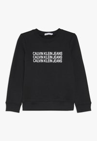 Černá mikina vyrobená z bavlny, s kulatým výstřihem a pružnými manžetami. Na přední straně je opakovaný bílý text "CALVIN KLEIN JEANS".
