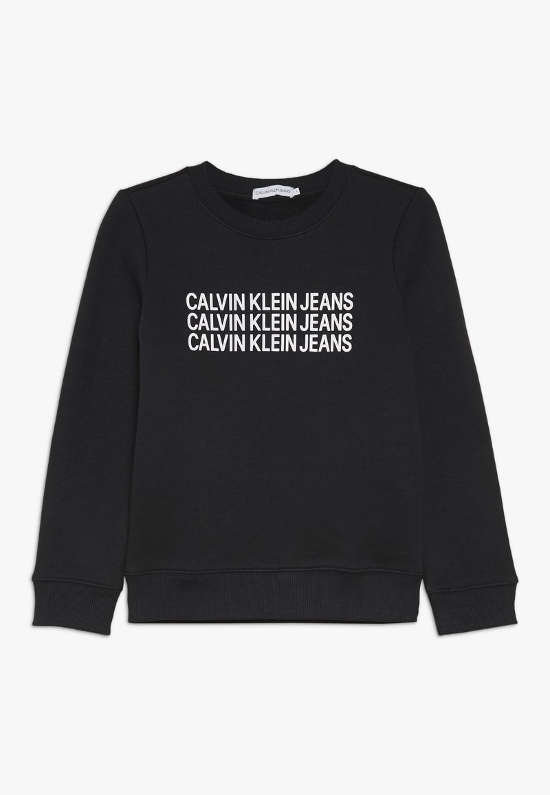 Černá mikina vyrobená z bavlny, s kulatým výstřihem a pružnými manžetami. Na přední straně je opakovaný bílý text "CALVIN KLEIN JEANS".