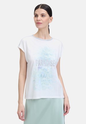 T-shirt en coton blanc avec une coupe décontractée, un col rond et des manches courtes. Présente un imprimé abstrait bleu et un texte argenté "PARADISE feelings."