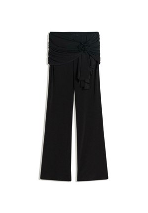 Schwarze, weit geschnittene Hose aus weichem Stoff mit einem drapierten, gerüschten Bund und einer gebundenen Detail vorne. Flache, glatte Textur.