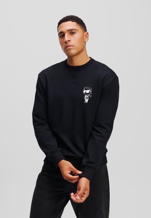 Zwarte sweatshirt van katoen met een ronde hals. Bevat een witte grafische afbeelding op de borst en ribgebreide manchetten en onderrand.