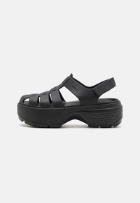 Sandales noires moulées avec un design à bout ouvert, comportant plusieurs sangles sur le pied et un large talon pour le soutien. Semelle texturée pour une meilleure adhérence.