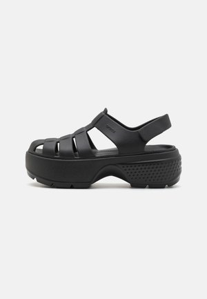 Black molded sandals with open-toe design, featuring multiple straps across the foot and a wide heel for support. Textured sole for grip.