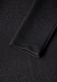 Tissu noir côtelé avec un subtil éclat métallique, présentant des lignes verticales distinctes et une finition lisse et texturée.