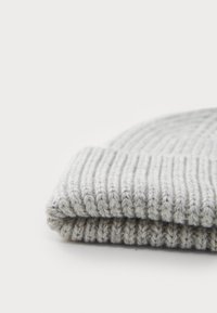 Bonnet en tricot gris avec une texture côtelée. Présente un revers, un matériau doux et une apparence épaisse et confortable. Design simple et neutre.
