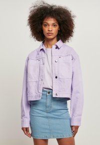 Lavendelklippt denimjacka med två framfickor, silverfärgad hårdvara och kragdesign, matchad med en ljusblå denimkjol.
