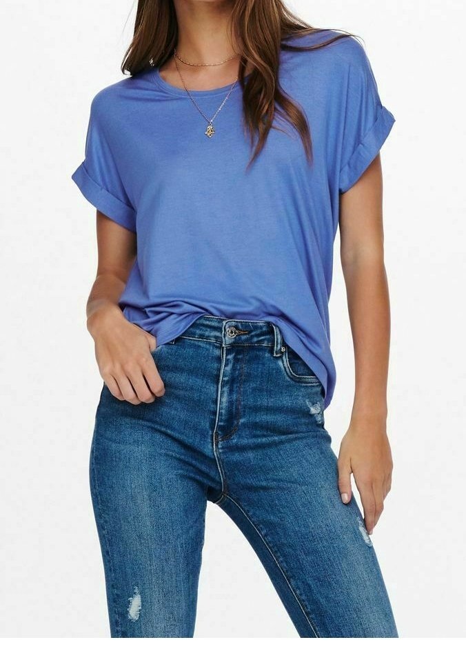 Femme portant un t-shirt bleu à manches retroussées, rentré dans un jean bleu taille haute avec une légère usure et un collier pendentif.