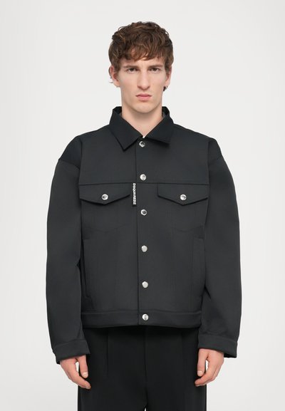 Veste noire au design structuré, avec un col, deux poches avant, des boutons métalliques et des détails de surfilage contrastants.