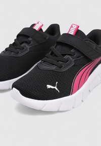 Baskets noires de sport avec un matériau en maille, fermeture par lacets et bande, semelle extérieure blanche et accents roses présentant le logo Puma.