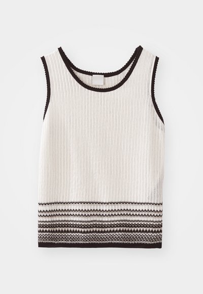 Bijela rebrasta majica bez rukava s crnim rubovima i dekorativnim horizontalnim prugama na donjem rubu. Tkanina izgleda teksturirano i pripijeno.