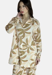 Camicia a maniche lunghe a fantasia floreale in morbido tessuto; presenta colori crema, verde e ruggine. Chiusura a bottoni e design del colletto classico.