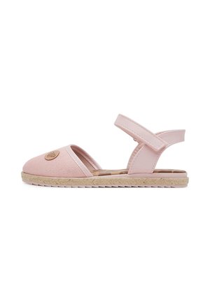 Jasnoróżowa płaska sandałka z zakrytym noskiem, regulowanym paskiem wokół kostki, plecioną podeszwą i okrągłym logo na obszarze palców, widziana z boku.