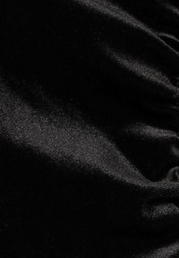 Black satin fabric with a smooth, shiny texture, featuring soft wrinkles and folds that reflect light.