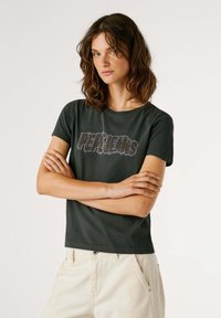 Camiseta de algodón verde oscuro con un gran logo texturizado de "PEPE JEANS" en colores contrastantes. Manga corta y cuello redondo.