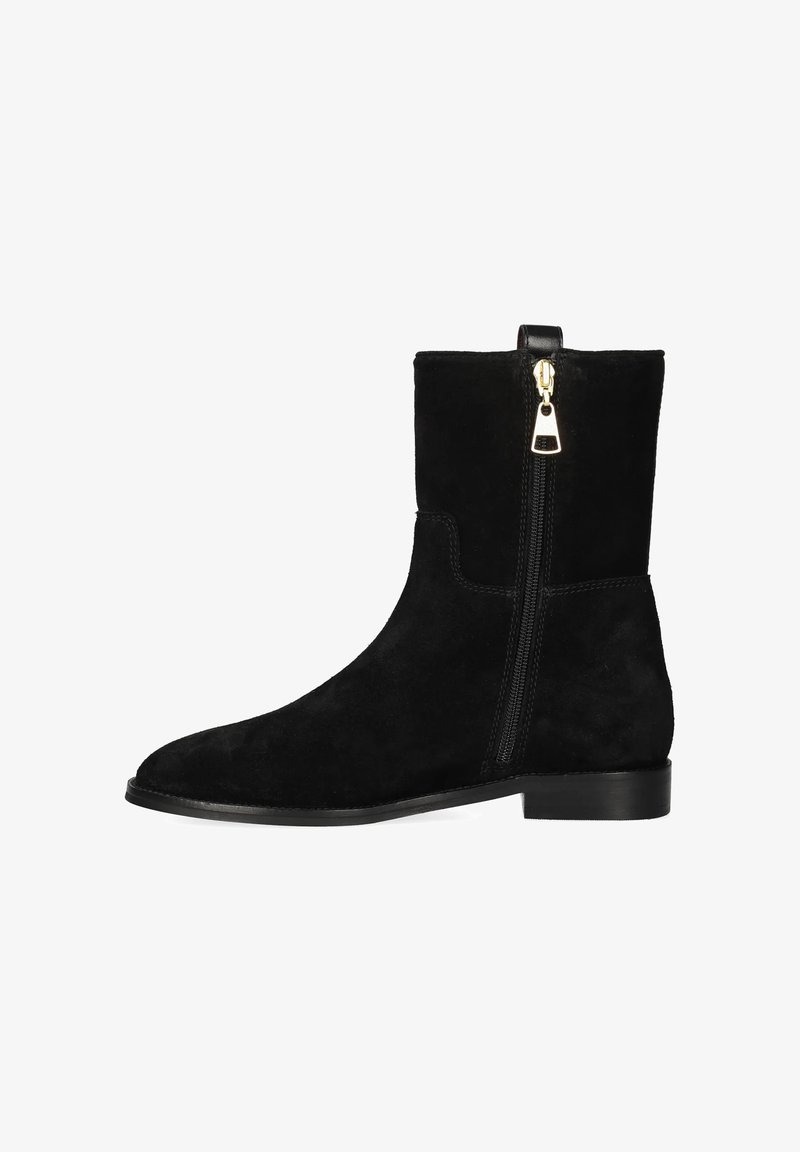 Botín de ante negro con cremallera lateral y tacón bajo, diseño elegante sobre un fondo blanco.