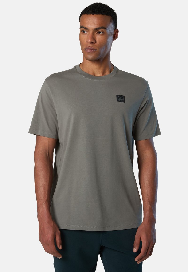 Graues T-Shirt mit kurzen Ärmeln aus weichem Stoff, mit rundem Hals und einem kleinen schwarzen Logopatch auf der Brust.