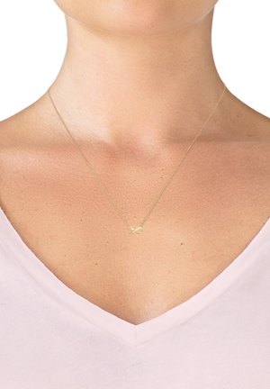 Gold infinity necklace on a thin chain, positioned at the collarbone, with a smooth, polished finish and minimalistic design.