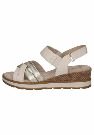 Helle beige Wedgesandalen mit metallischen Akzenten, Kreuzriemen und verstellbarem Knöchelriemen. Sie verfügen über einen strukturierten, geflochtenen Absatz und eine gepolsterte Innensohle.