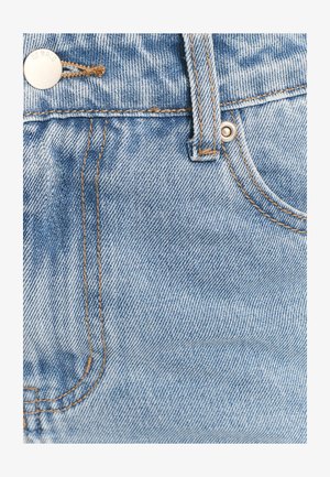 Gaiši zils džinsa audums ar klasisku dizainu, redzamas šuves kontrastējošā brūnā krāsā un metāla pogas aizdare uz jostasvietas.