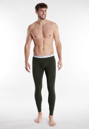 Olivgrüne thermo Leggings aus weichem Stoff mit einem weißen elastischen Bund, auf dem der Markenname steht. Schlank geschnittenes Design, knöchellange Ausführung.