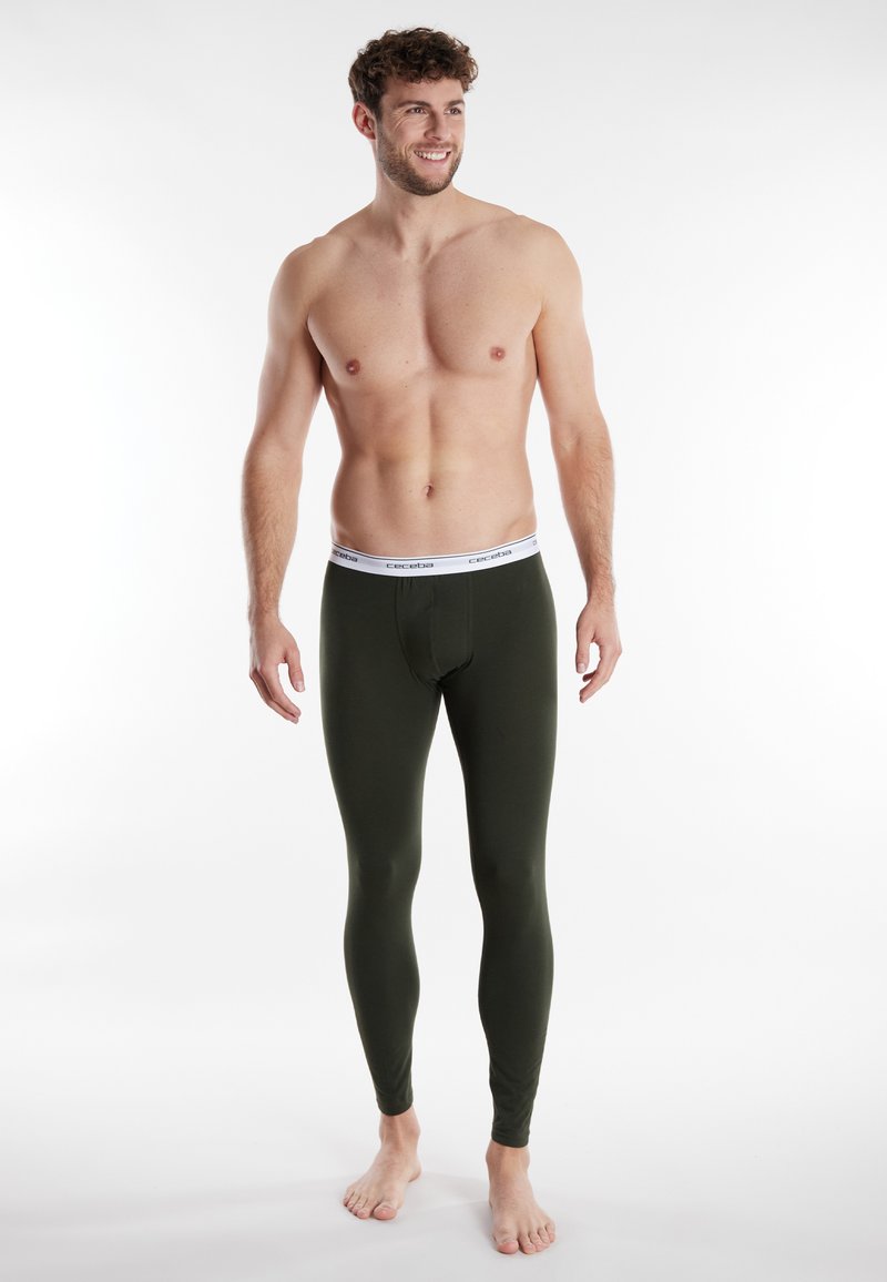 Leggings termici verde oliva realizzati in morbido tessuto con vita elastica bianca in evidenza del nome del marchio. Design slim-fit, stile alla caviglia.