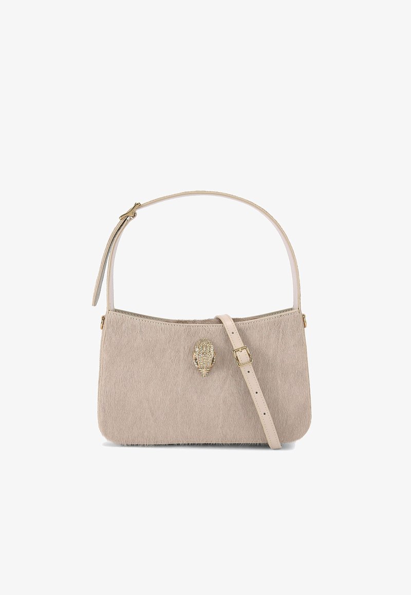 Beżowa torebka z futra syntetycznego z gładkim skórzanym paskiem, z dekoracyjnym zapięciem w złotym kolorze o teksturowanym wzorze. Zapięcie jest wyraźnym detalem.