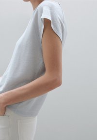 Vaaleansininen lyhythihainen paita, jossa on rento istuvuus ja pyöreä pääntie. Valmistettu teksturoidusta kankaasta, jossa on lieviä ryppyjä hihoissa.