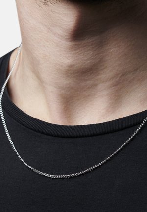 Silver chain necklace resting on a bare neck, featuring a twisted design and a smooth texture, with a black crew-neck shirt in the background.