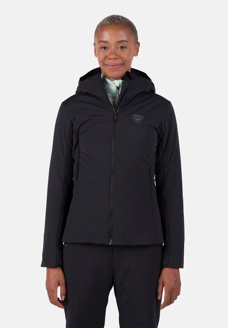 Schwarze Kapuzenjacke mit einem frontalen Reißverschluss und Logo auf der Brust. Verfügt über ein nahtloses Design und ein strukturiertes Material, geeignet für Outdoor-Aktivitäten.