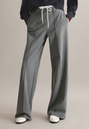 Graue, weit geschnittene Hosen aus strukturiertem Stoff mit Falten und elastischem Bund; ausgestattet mit einem Kordelzug und seitlichen Taschen.